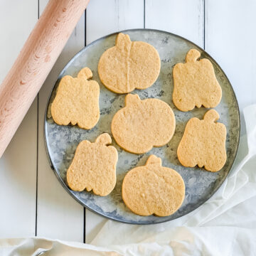 pumpkin shaped cut out cookies on a tray