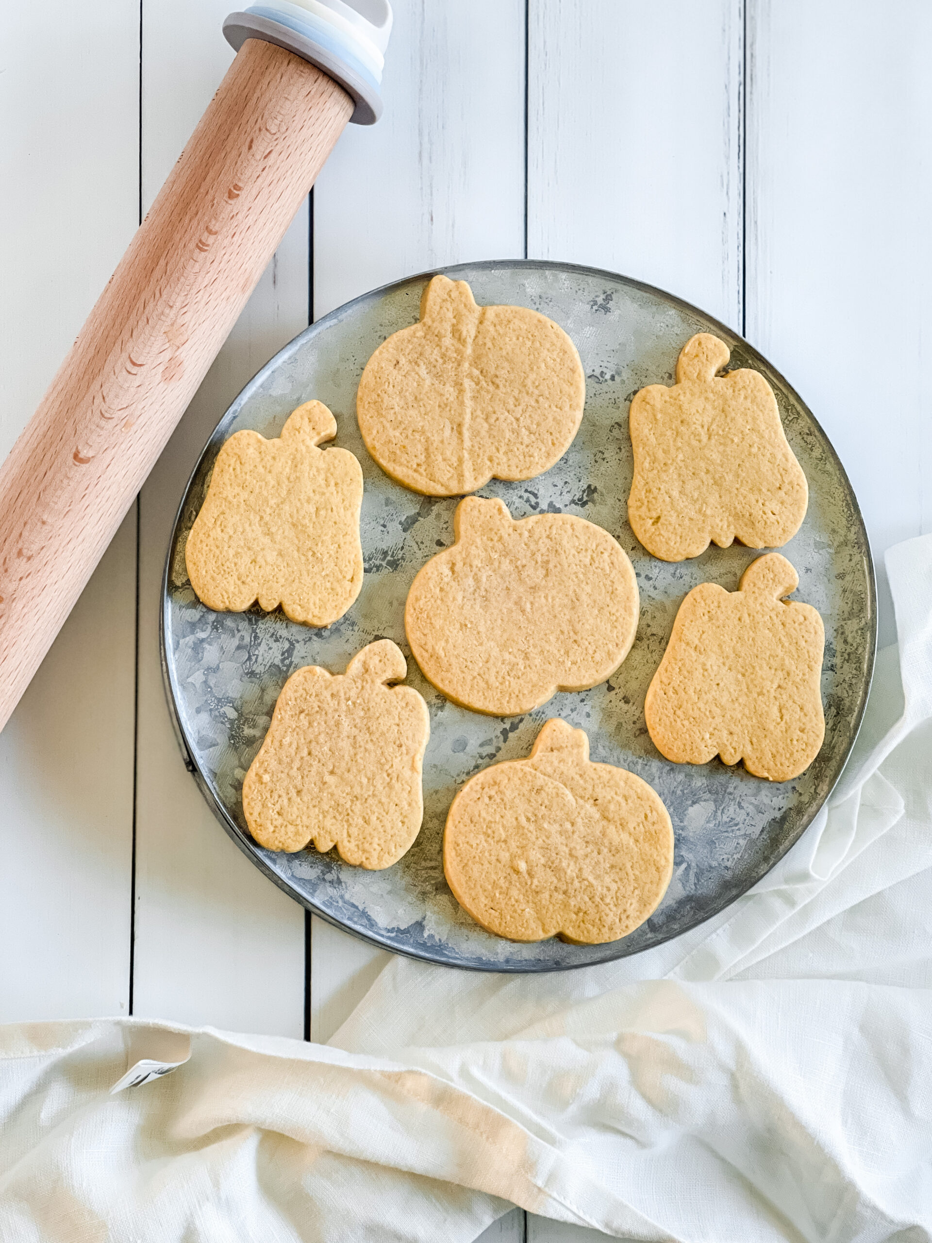 pumpkin shaped cut out cookies on a tray