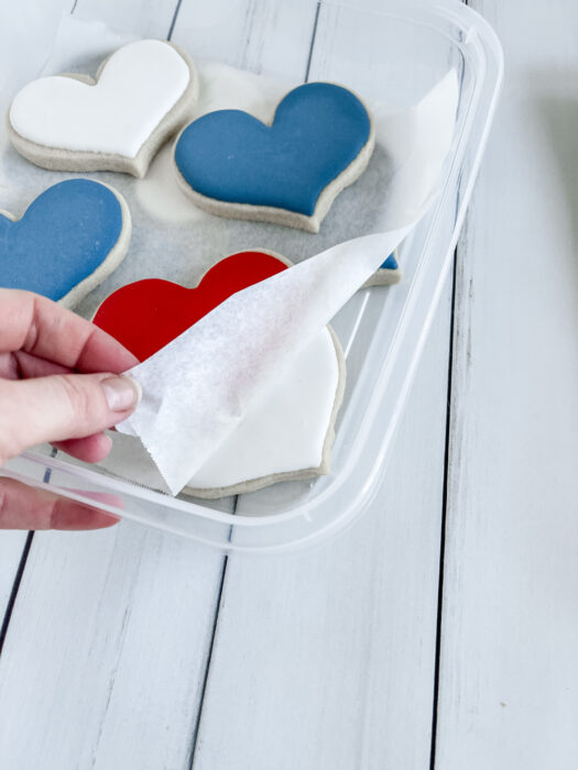 parchment paper between royal icing cookie layers