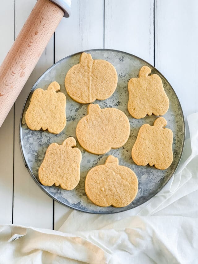 pumpkin shaped cut out cookies on a tray