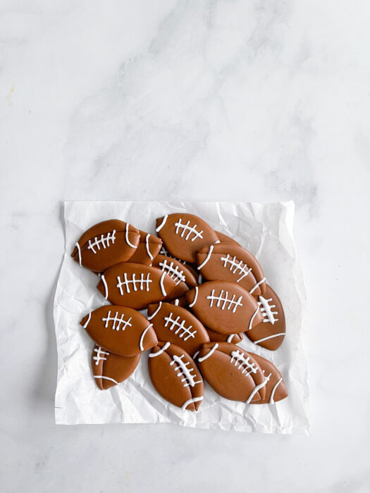 stack of royal icing football transfers on a piece of parchment paper