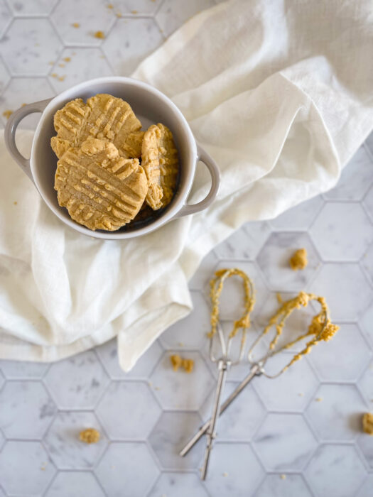 peanut butter cookies in bowl with beaters covered in peanut butter