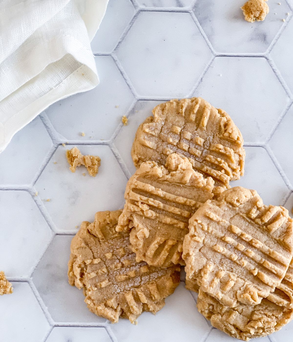 5 Peanut butter cookies sitting on a marble counter.