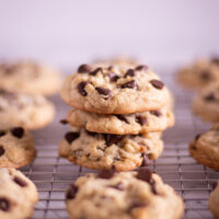chocolate chip cookies stacked on a cooling rack