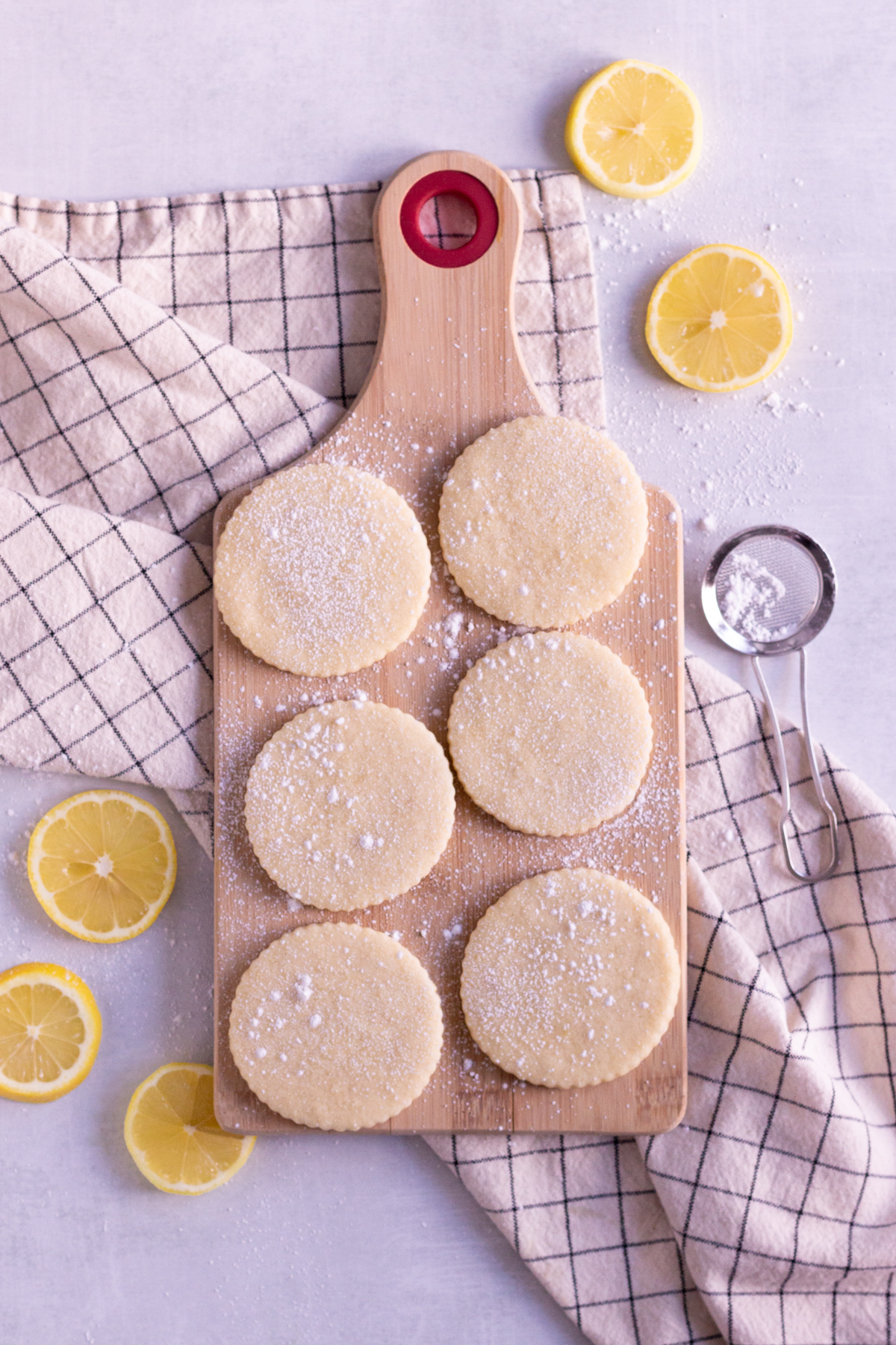 6 baked lemon cookies on a cutting board