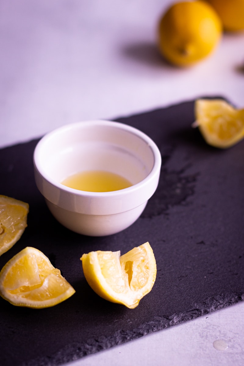 lemons being squeezed into small bowl