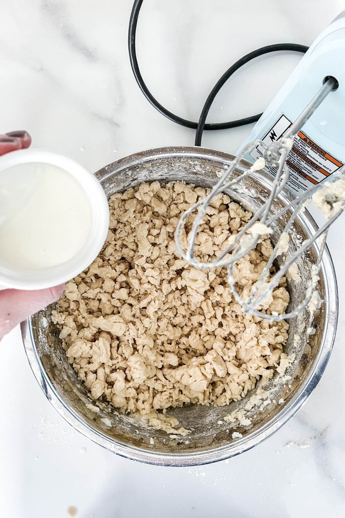 adding milk to dough