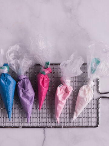 5 royal icing bags on a drying rack