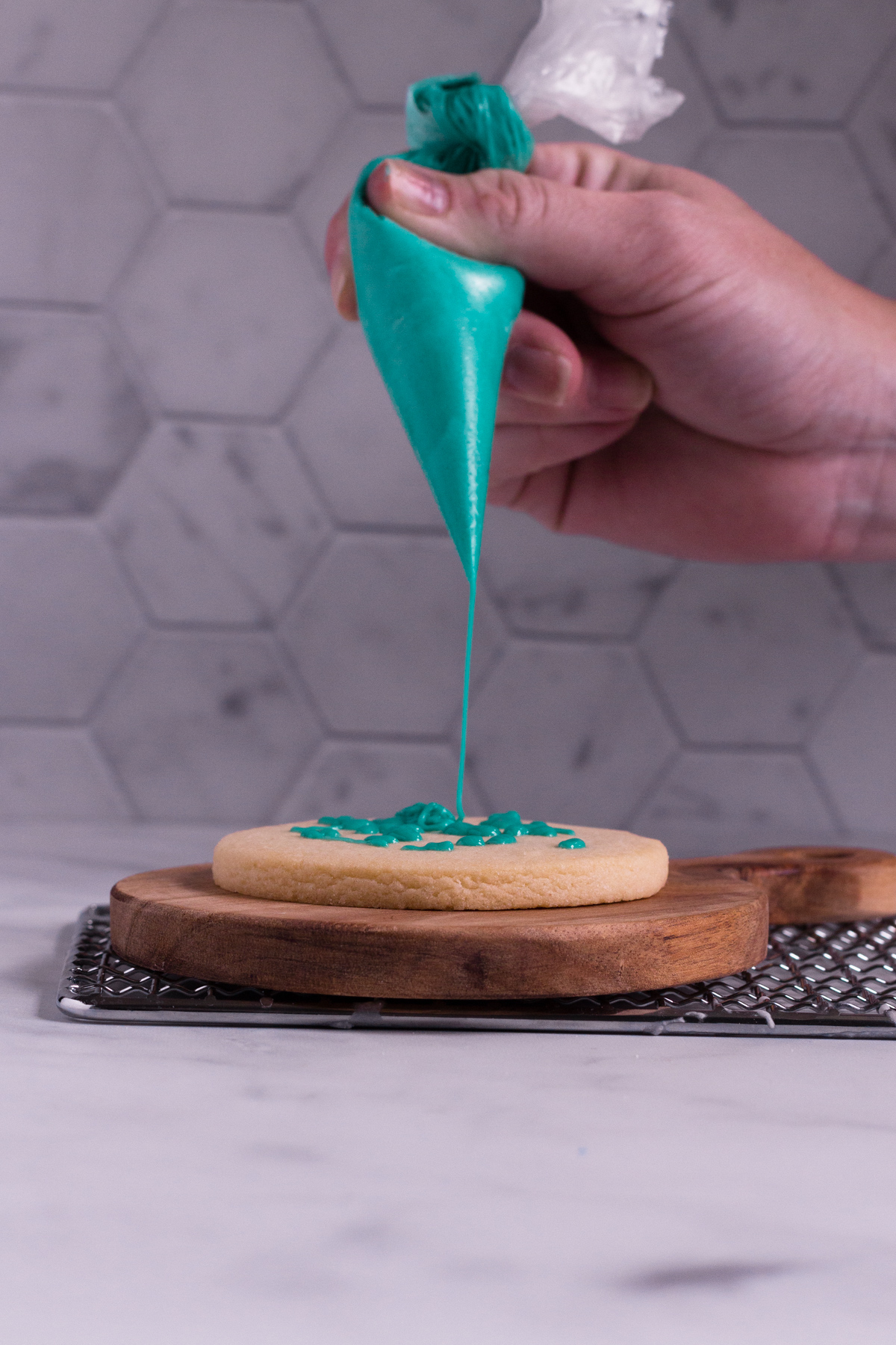 drizzling royal icing onto a cookie