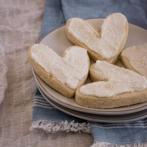 Frosted almond sugar cookies on a plate.