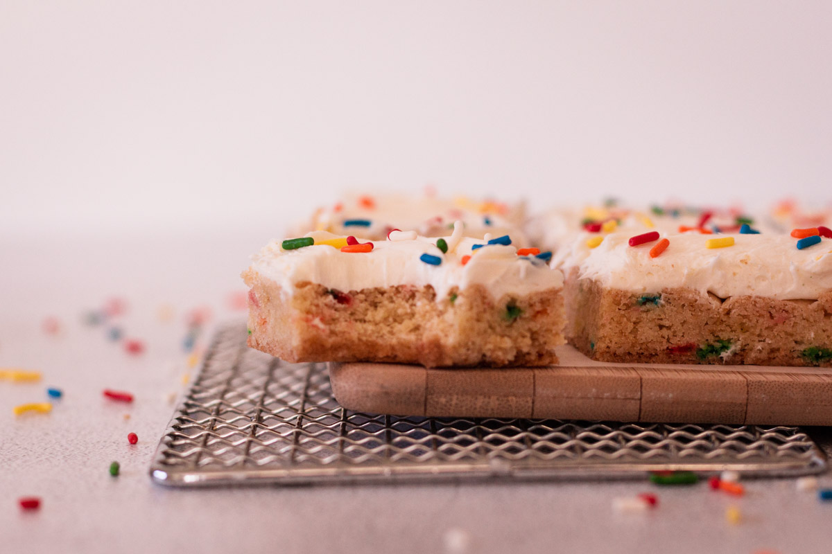 Side view of cookie bars with a bite taken out of the one in the front. 