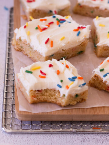An up-close picture of a funfetti cake mix cookie bar with a bite taken out of it.
