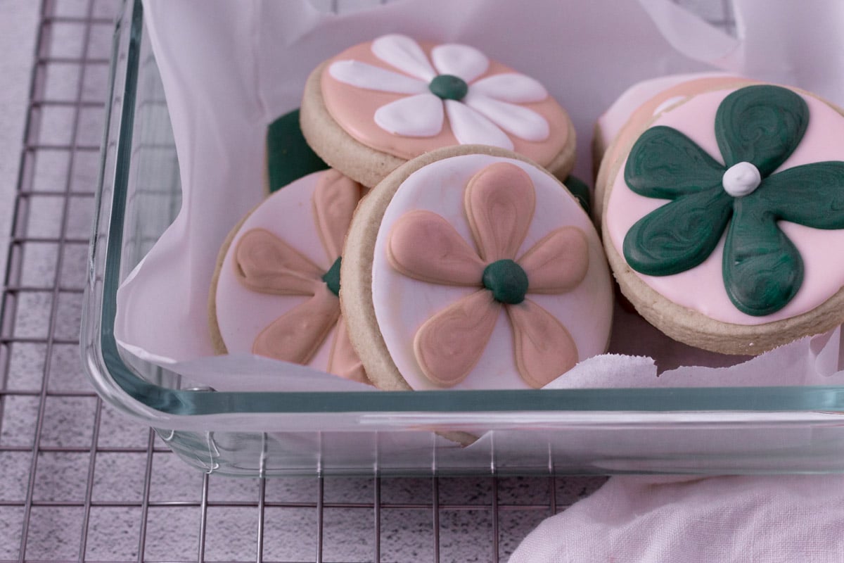 Royal icing cookies stored in glass container.