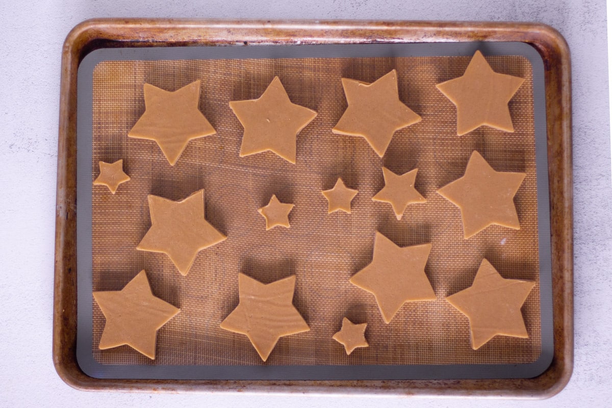 Unbaked cut-out cookies on a baking sheet. 