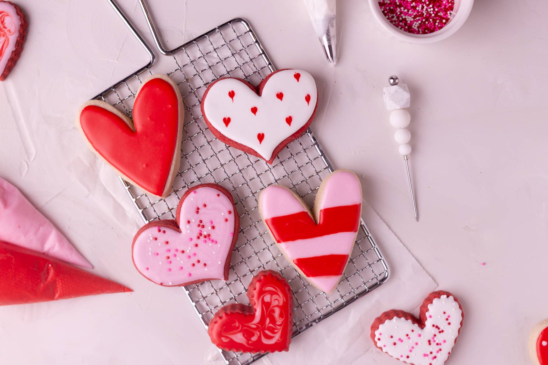 Heart cookies on a wire rack with royal icing. 