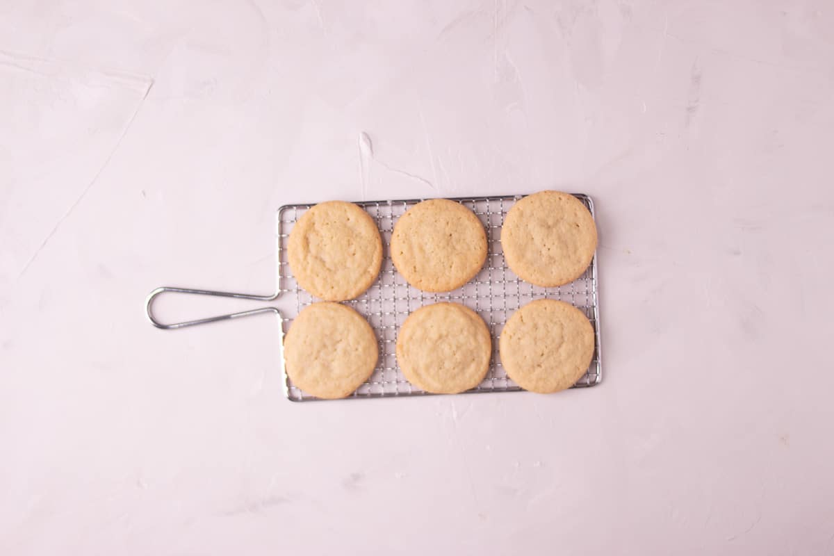 Baked sugar cookies cooking on wire rack.