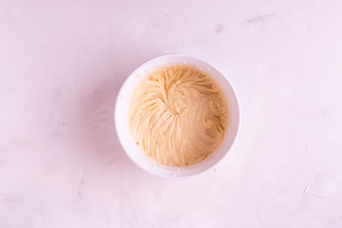 Egg and vanilla added to butter mixture in a bowl.