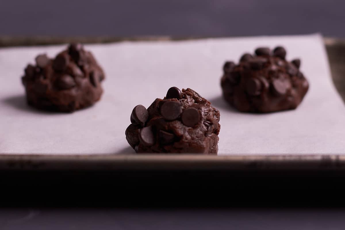 Cookie dough balls on cookie sheet before baking. 